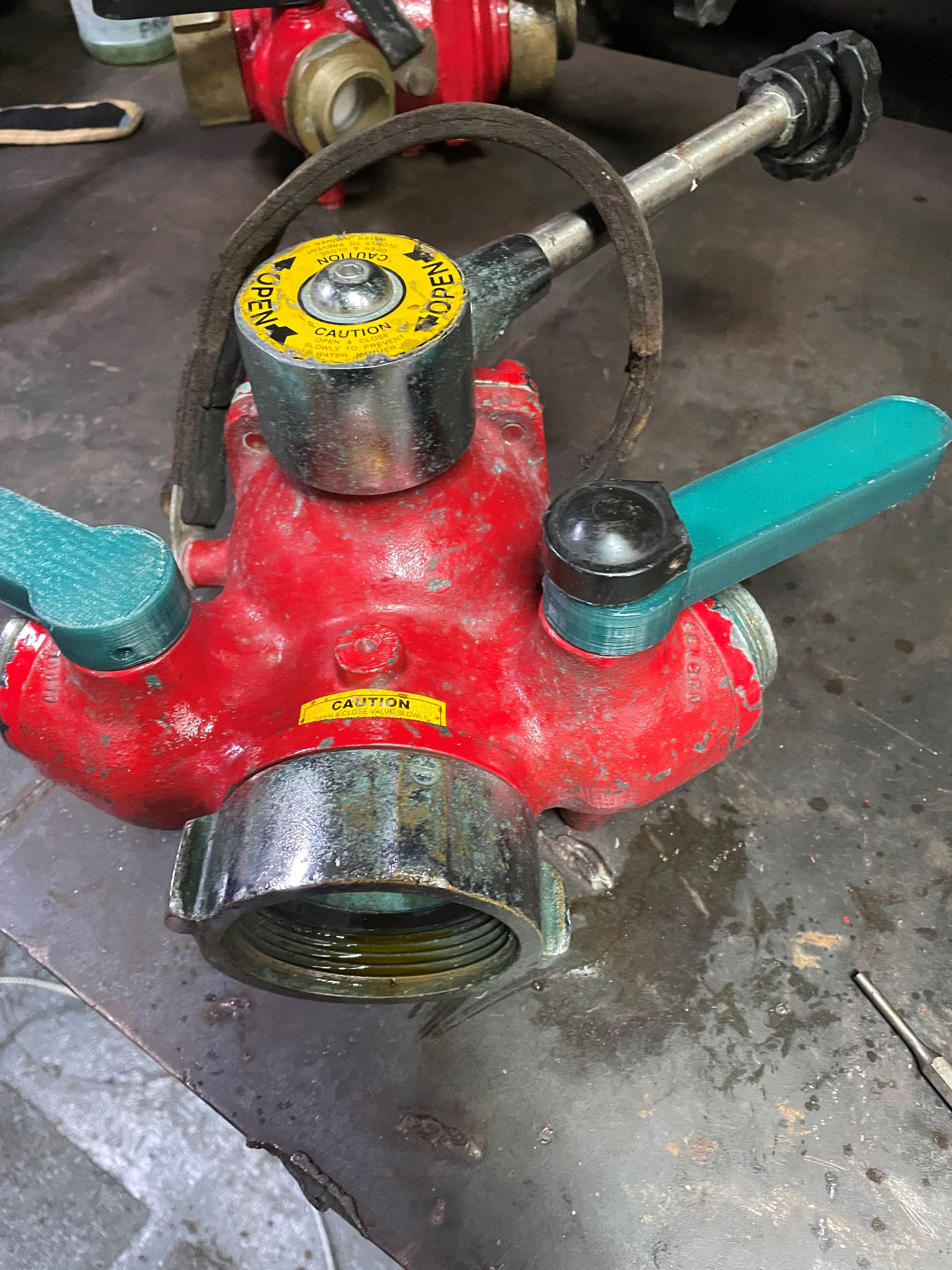 Members serving aboard the Coast Guard Cutter Venturous used a 3D printer to replace broken and cracked handles on the Y-gate, which is a part which allows a fireplug to feed two separate hoses. The handles are used to direct the flow of water. (U.S. Coast Guard photo.) 