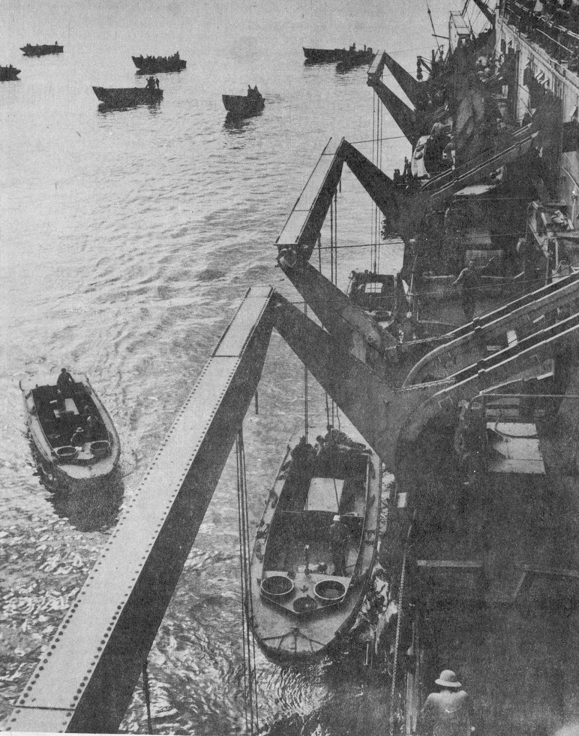 A troop transport lowering landing craft off the shores of Guadalcanal in 1942. (U.S. Navy)