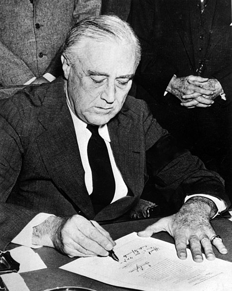 President Franklin Roosevelt signing the declaration of war against Japan. (National Archives)