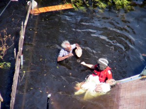 A Coast Guard rescue swimmer saving an elderly victim in 2005’s Hurricane Katrina. (U.S. Coast Guard Collection)