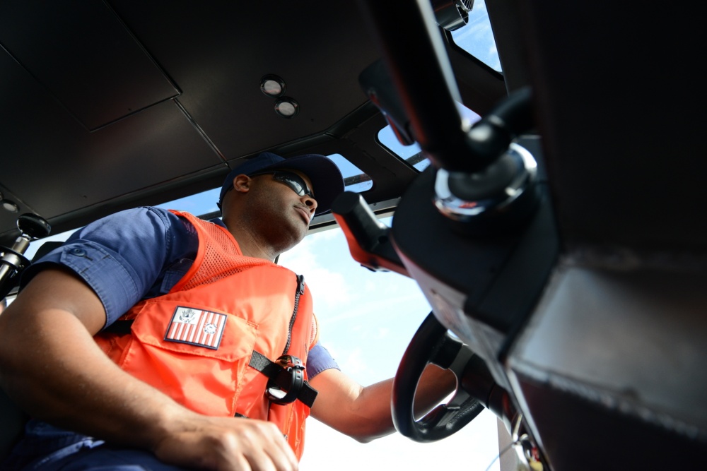 Petty Officer 3rd Class Lowell Belany, a reserve boatswain's mate out of Coast Guard Station Vallejo, Calif., takes the helm while navigating waypoints along the Columbia River during the Reserve Coxswain College in Portland, Ore., Aug 28, 2015. Students attending the college were required to plot out and navigate to waypoints using different on land reference points along the Columbia River. (U.S. Coast Guard photo by Petty Officer 3rd Class Jonathan Klingenberg